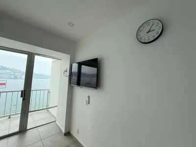 Una televisión o centro de entretenimiento en Departamento con vista al mar y playa privada