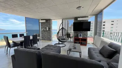 Una televisión o centro de entretenimiento en Departamento con vista al mar y campo de Golf