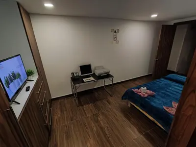 Una televisión o centro de entretenimiento en Hotel Origins