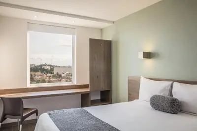Cama o camas de una habitación en One Puebla Serdan