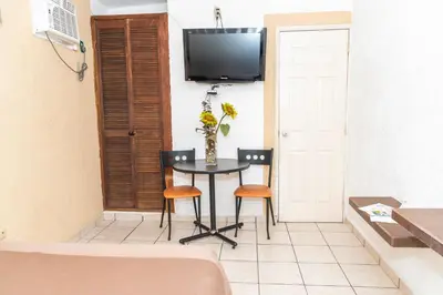 Una televisión o centro de entretenimiento en Hotel Villas Santa Ana