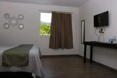 Una televisión o centro de entretenimiento en Hotel Garden Suites Tonalá